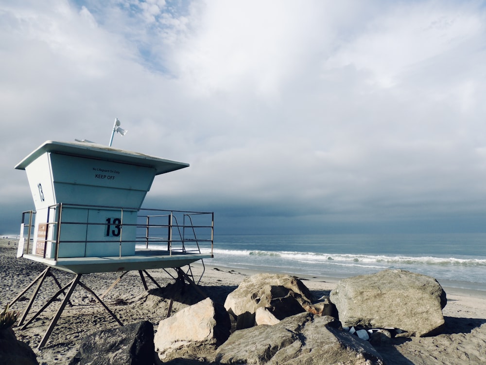 a lifeguard tower sitting on top of a sandy beach