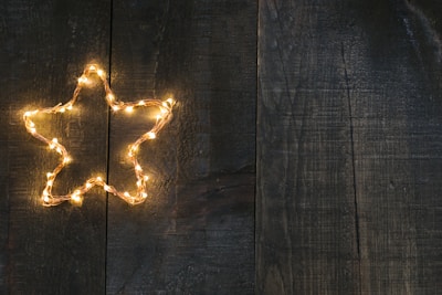 Festive decorative lights twinkling on a rustic wooden mantel during a holiday evening.