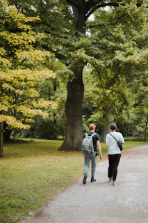 two people walking down a path in a park
