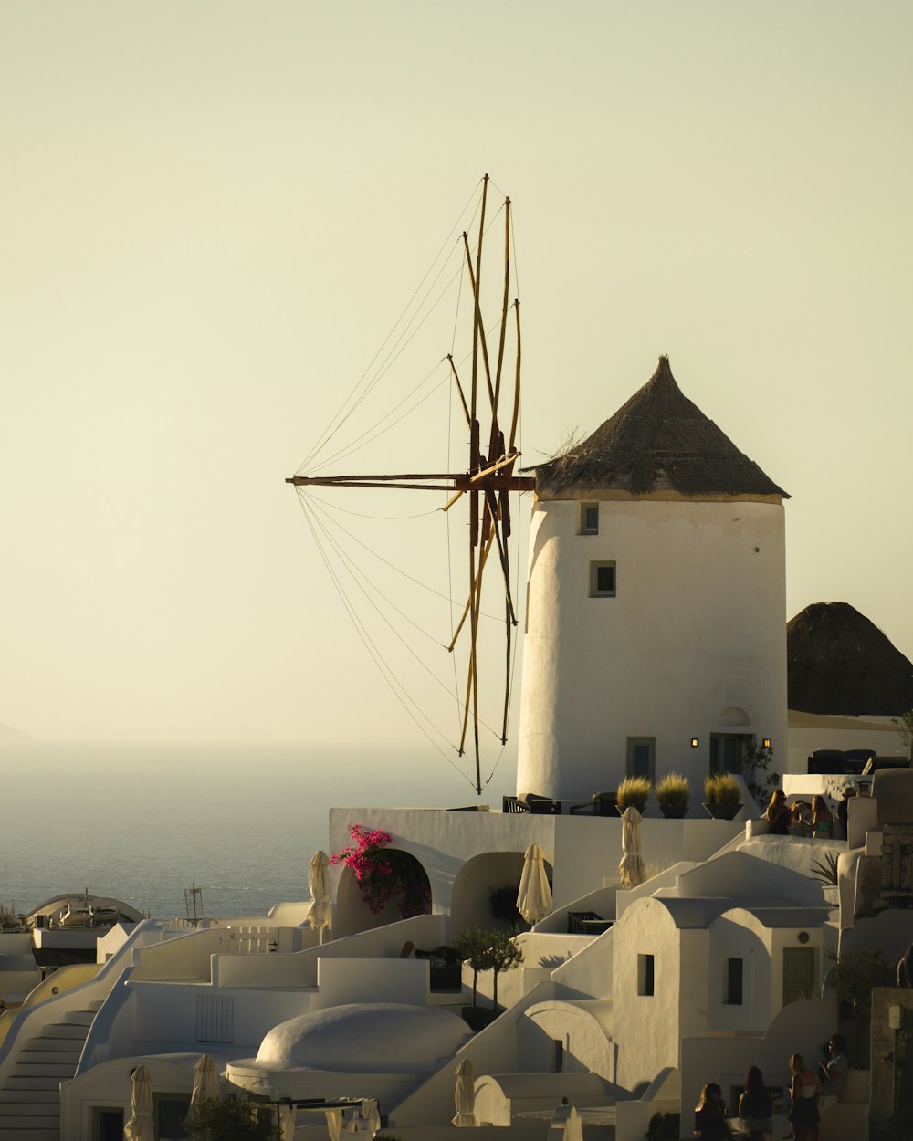 a windmill on top of a building near the ocean