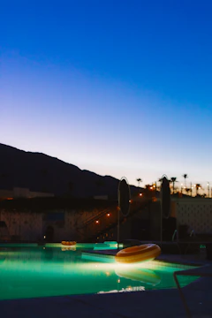 Underwater pool lights glowing in soft blue hues during twilight.
