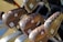 A close-up view of several golf clubs with wooden handles, featuring a distinct hammered texture. Each club is marked with numbers and logos, arranged neatly in a bag. The surface of the clubs appears polished with visible QR codes near the base.