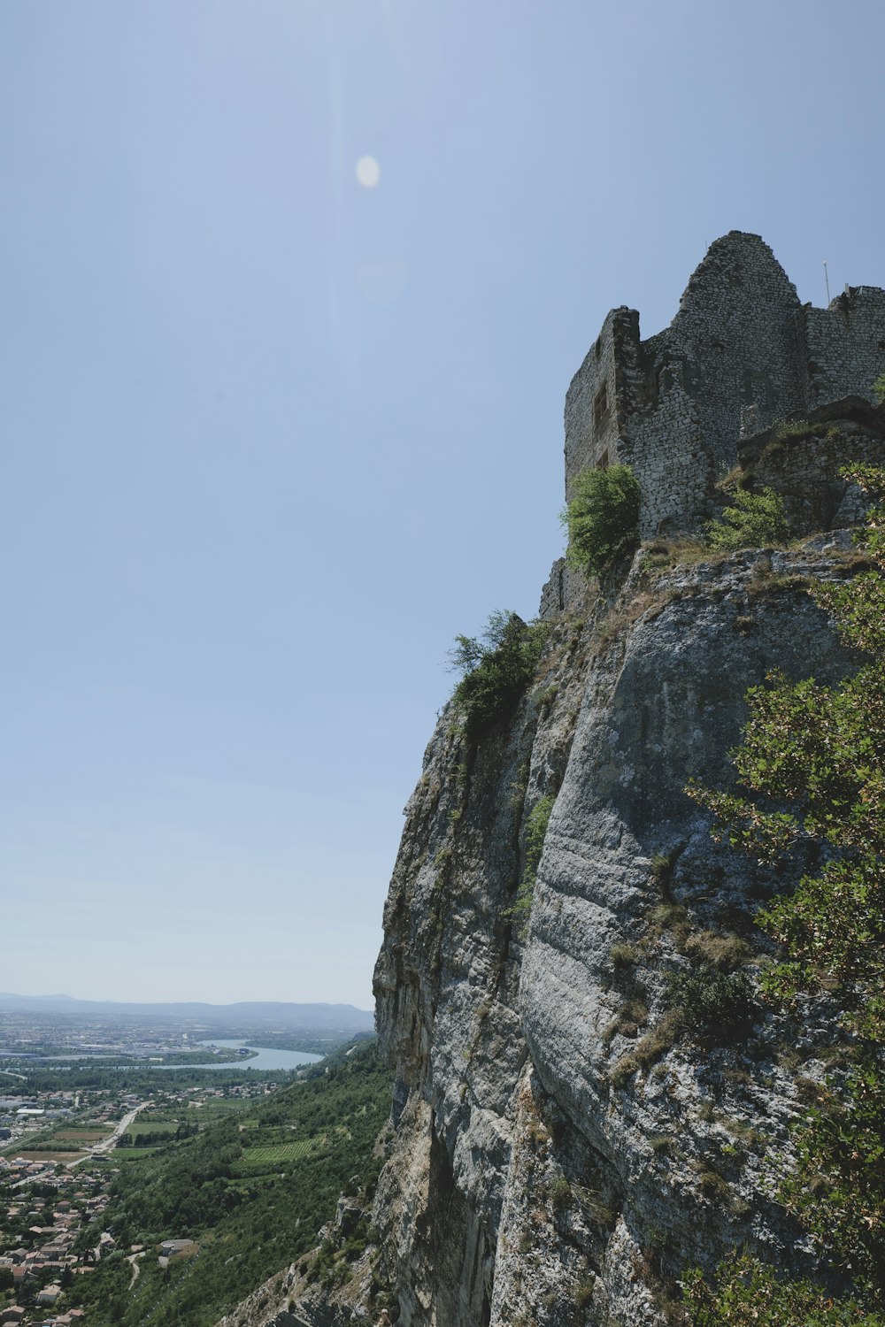 a castle on top of a cliff with a view of a valley below