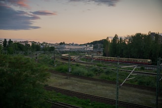 A serene train winding through a picturesque countryside at sunset.