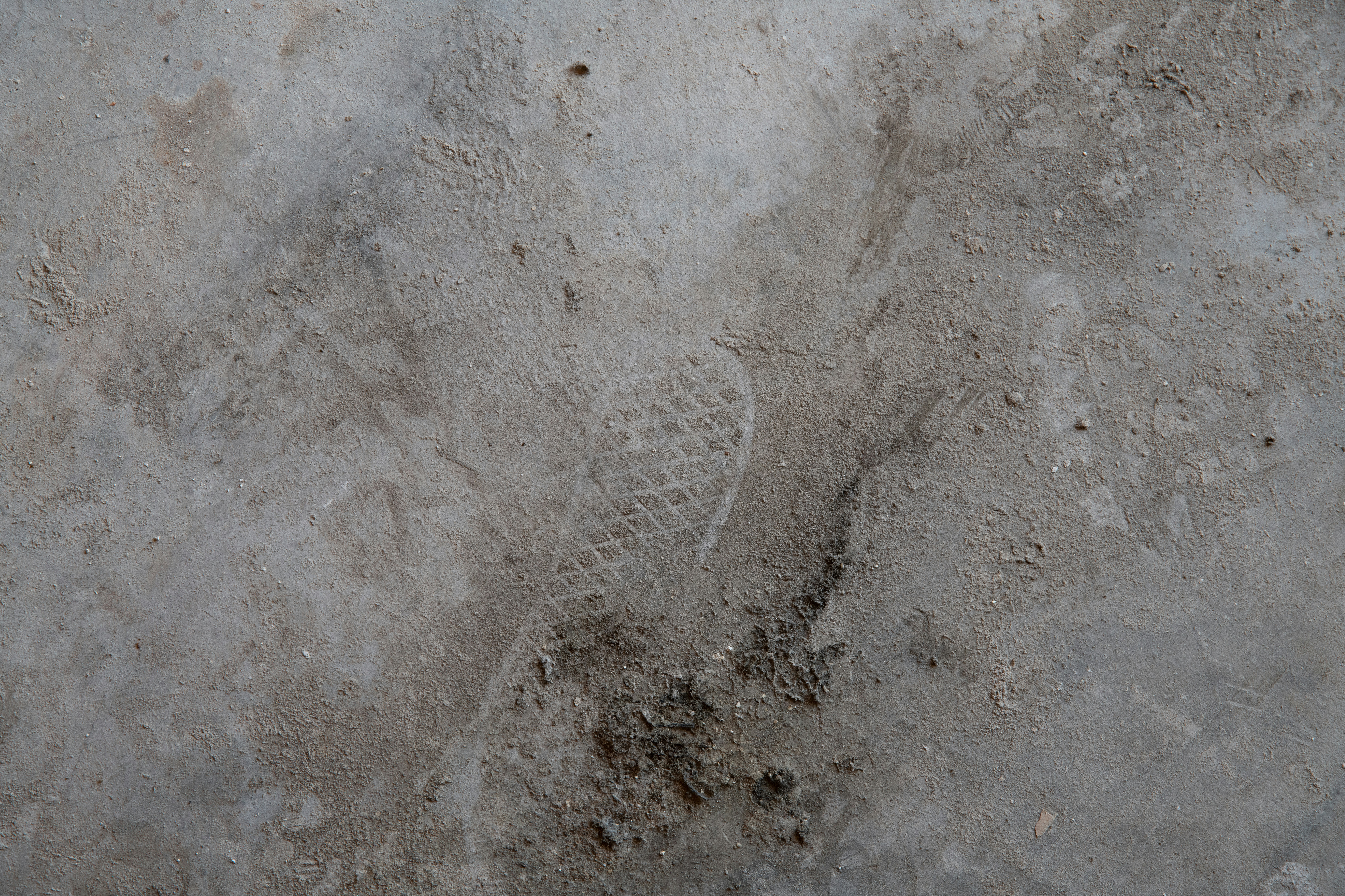 a close up of a cement surface with a shoe imprint