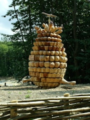 A rustic outdoor art display showcasing kids’ pinecone sculptures.