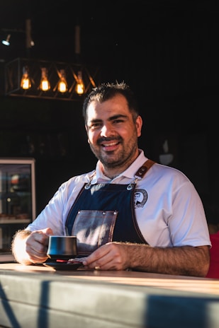 a man sitting at a table with a cup of coffee