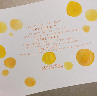Text written in orange ink on white paper surrounded by abstract yellow watercolor circles. The quote discusses telling children about God's glory and ensuring it continues forever. The signature at the bottom credits J Mark Navey from Provision Church.