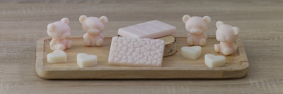 Colorful baby shower soaps shaped as tiny animals and baby items on a gentle fabric background.