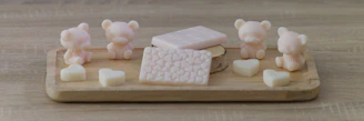 An inviting arrangement of scented candles and natural soaps on a wooden tray.
