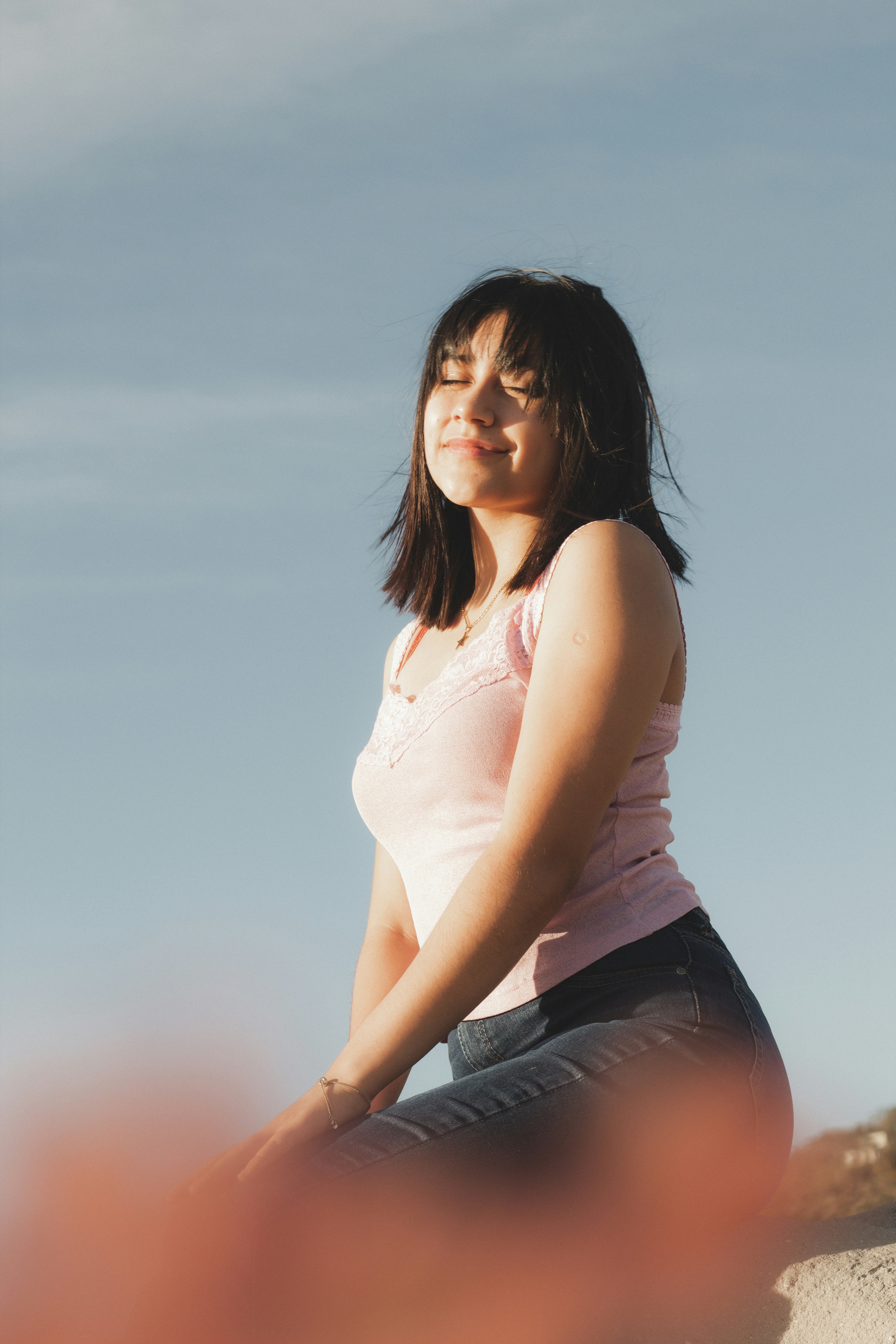 大きな岩の上に座っている女性の写真 Unsplashのフォトグラフィア・デ・レトラト・フェメニーノの無料画像