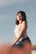a woman sitting on top of a large rock