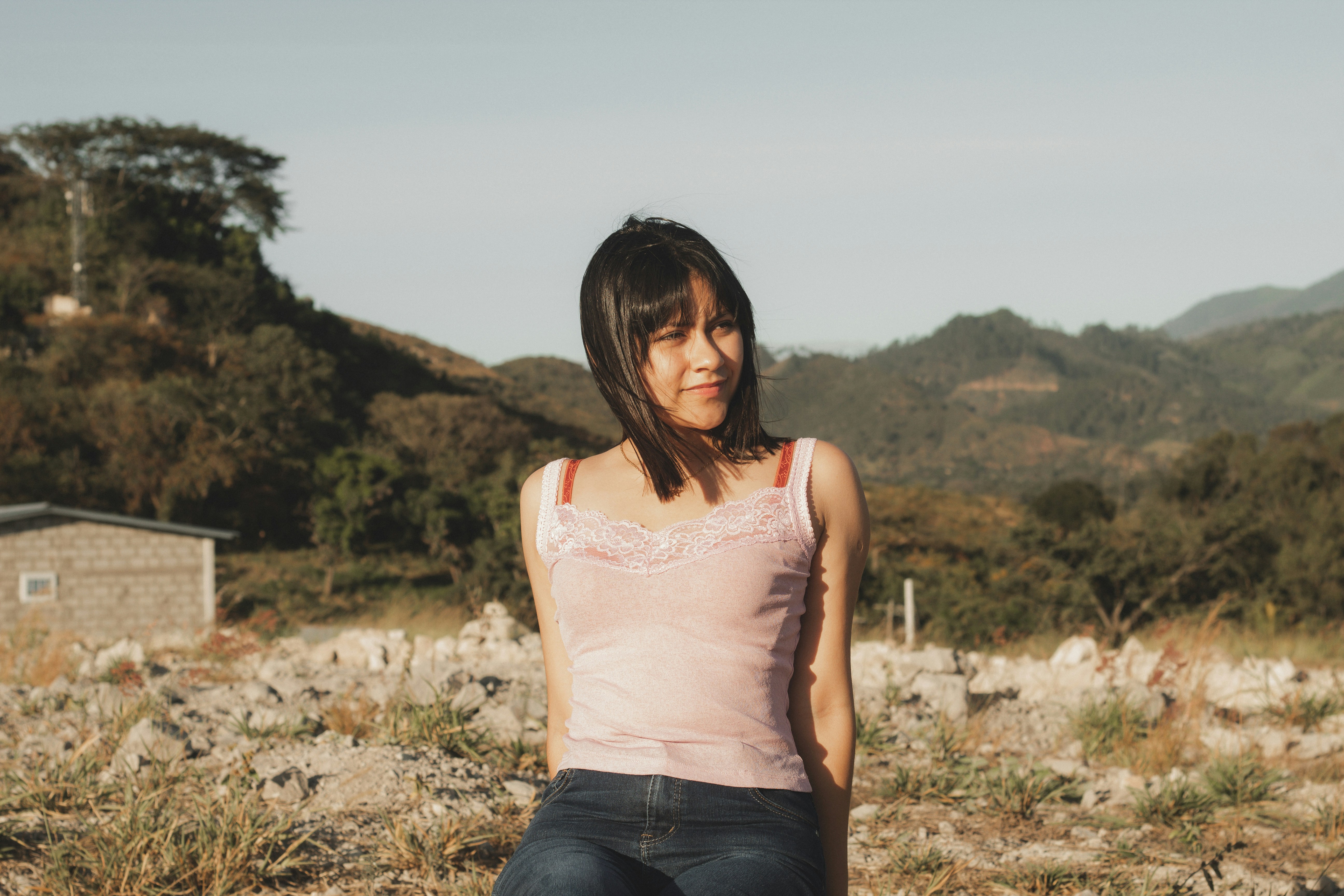 a woman sitting on a rock in a field