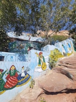 Volunteers painting vibrant murals on the walls of a rural classroom in India.