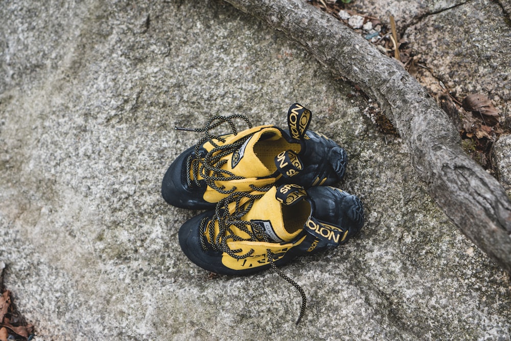 a pair of yellow and black shoes on a rock