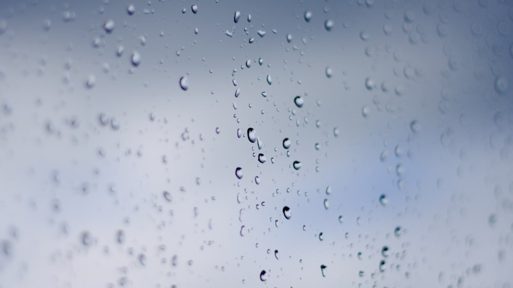 rain drops on a window with a blue sky in the background