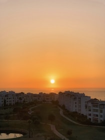 A serene view of luxury apartments with a sunset backdrop.