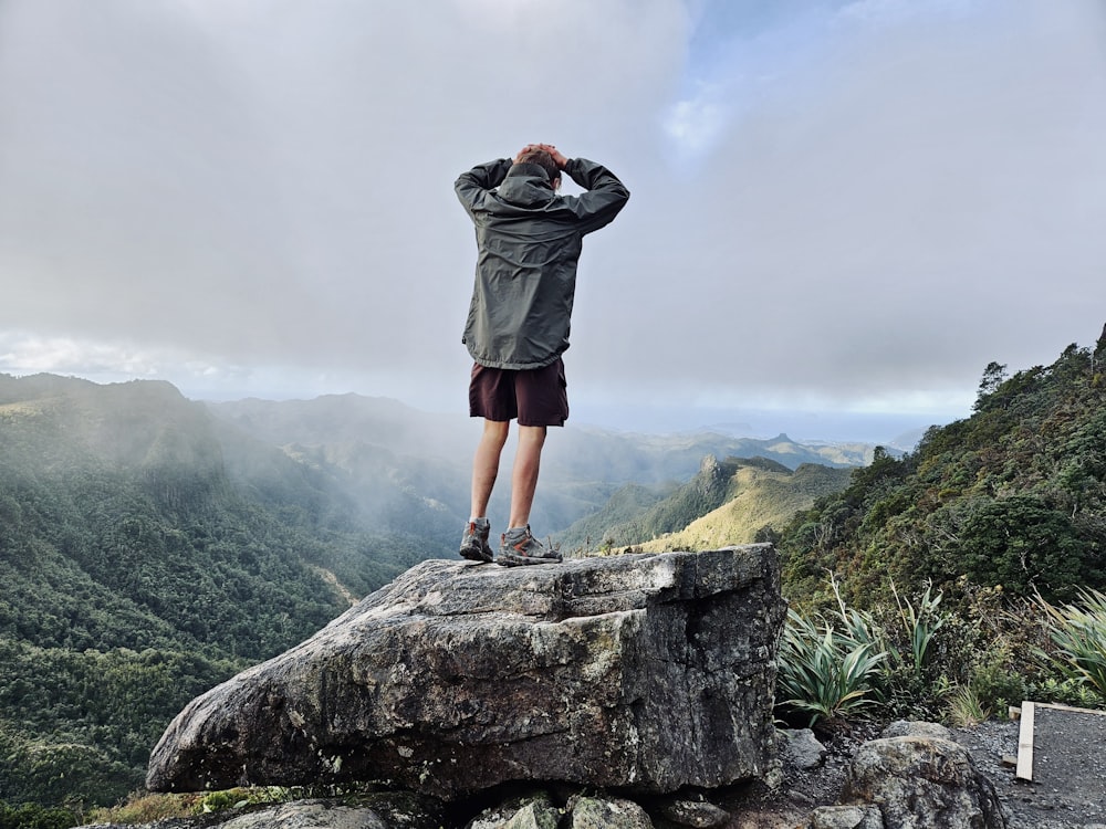 a man standing on top of a large rock