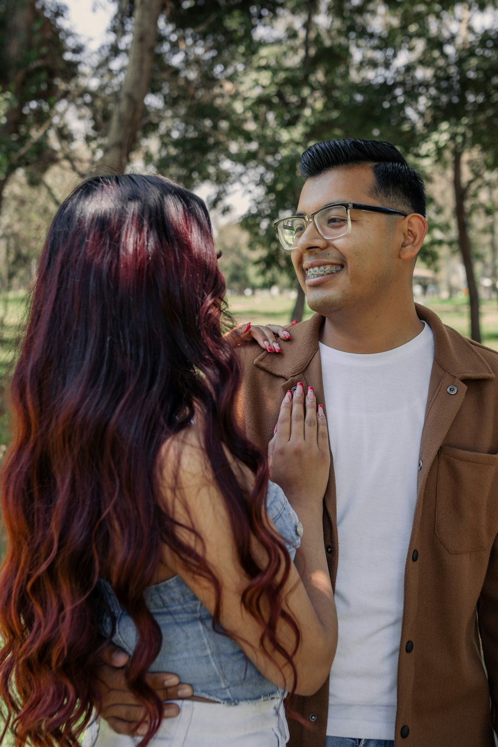 a man standing next to a woman in a park