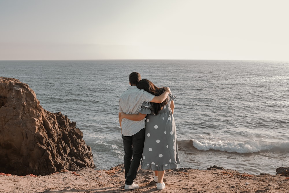 a man and a woman hugging on the beach