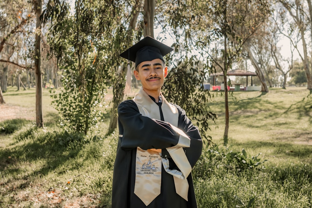 a man in a graduation cap and gown posing for a picture