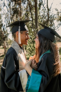 A warm handshake between two graduates in front of the university building.