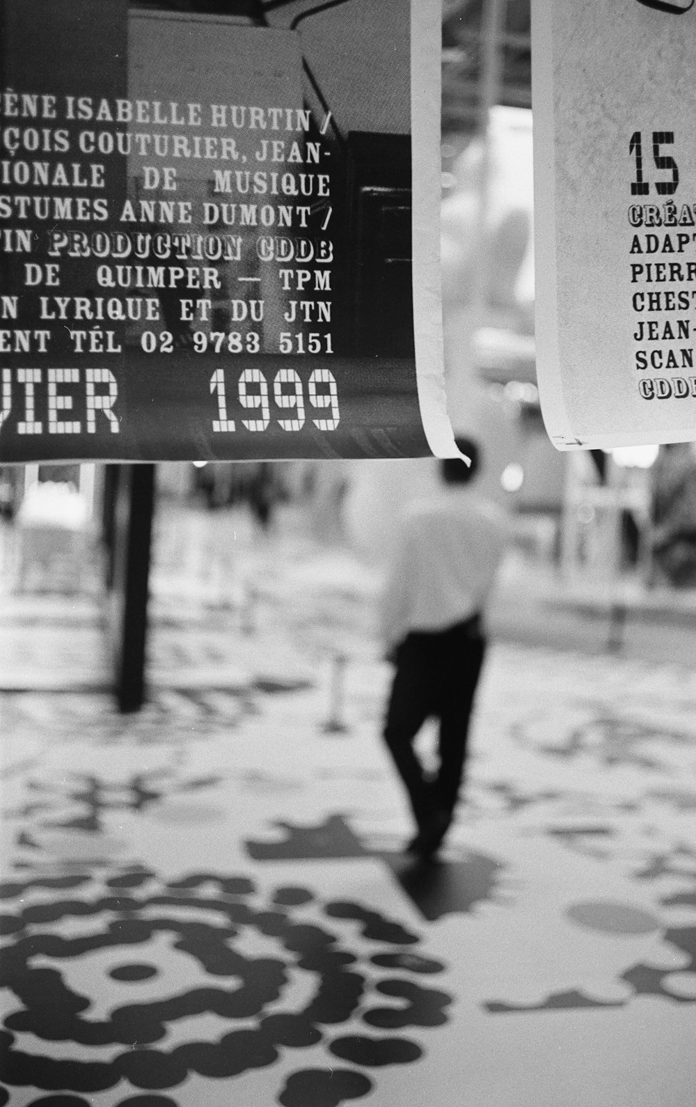 a black and white photo of a man walking down a street