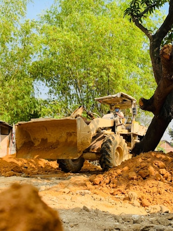 Operator controlling a large bulldozer moving earth on a hillside project.