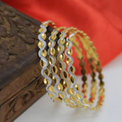 Elegant accessories like bangles and necklaces arranged on a traditional wooden table.