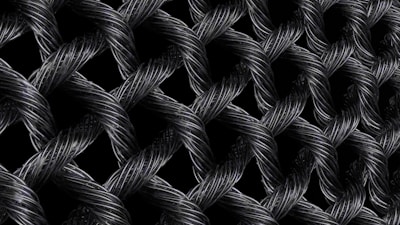Interwoven strands of dark, metallic wires form a textured, lattice-like pattern. The intricate braiding creates a sense of depth and complexity, with highlights emphasizing the reflective surface of the materials.