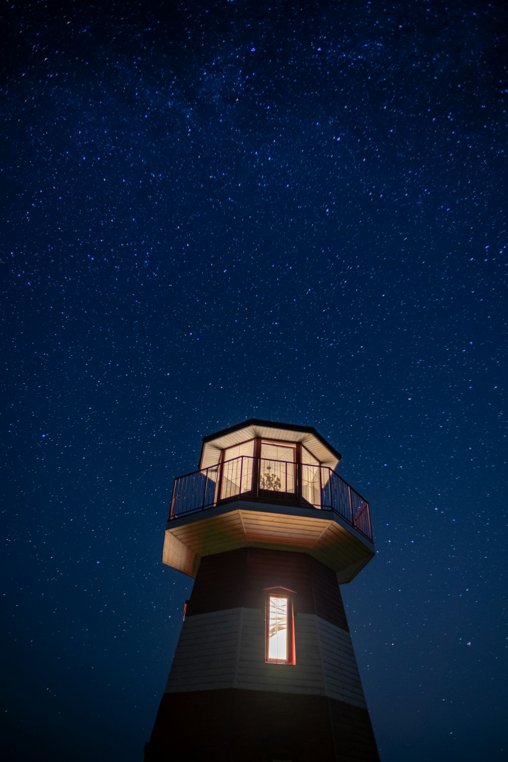 Un faro sotto un cielo notturno pieno di stelle