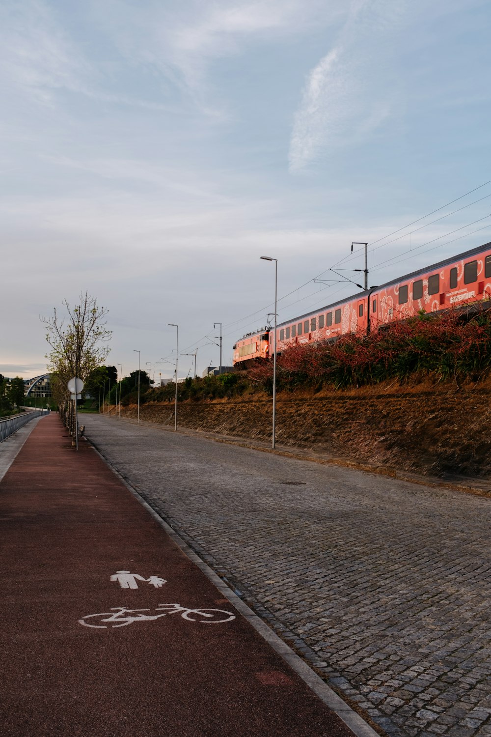 a red train traveling down train tracks next to a road