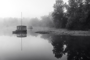 A tranquil houseboat gliding through misty mountain lakes at dawn.