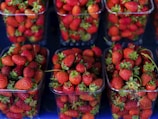a bunch of strawberries are in plastic containers