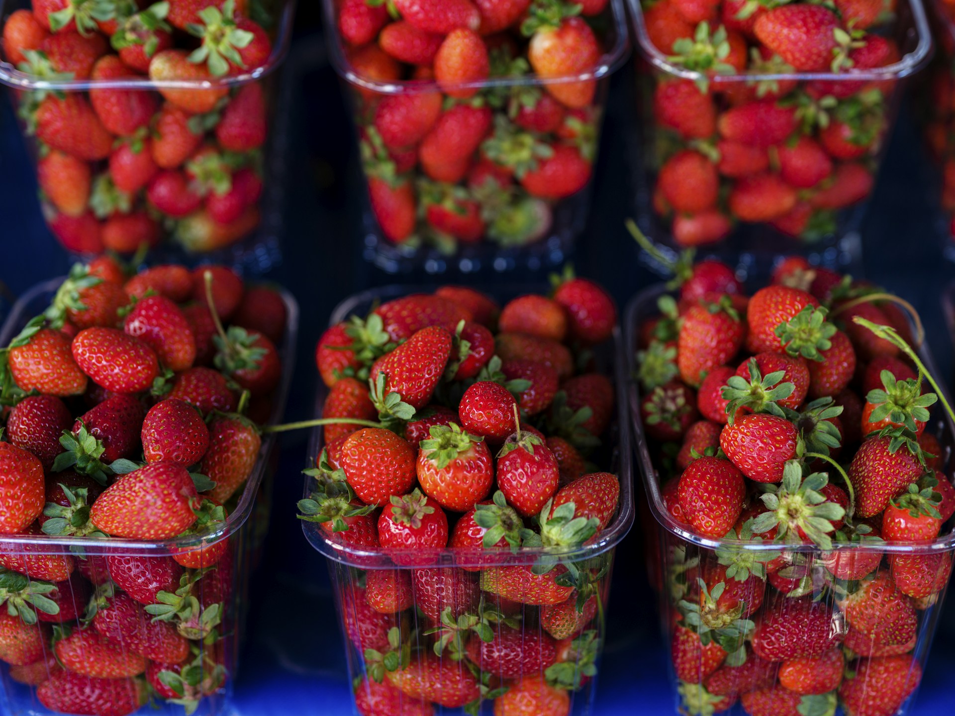 a bunch of strawberries are in plastic containers