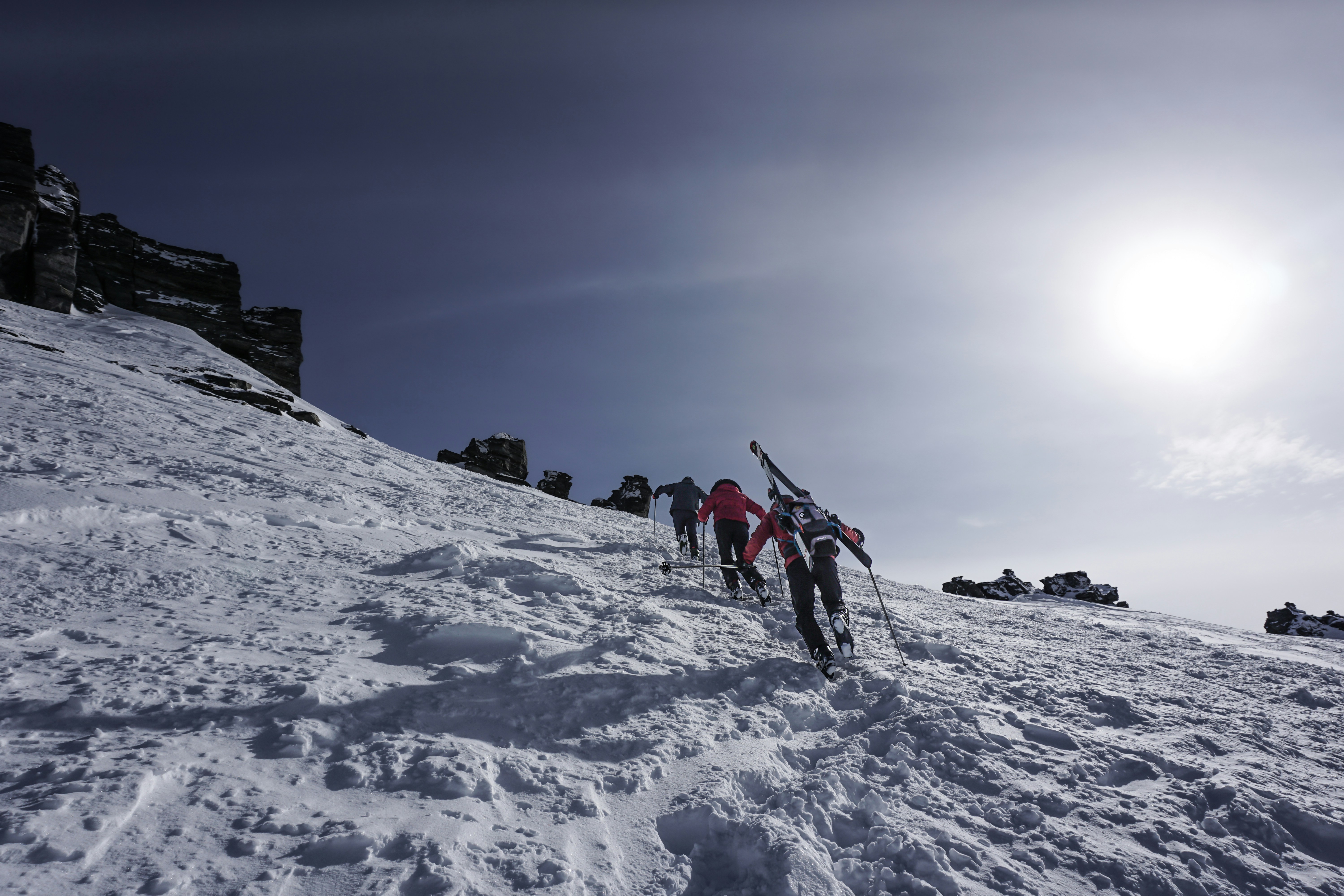 a group of people riding skis down a snow covered slope, The prime "hike to ski" area at Treble Cone is the Summit ridge at the top of the Saddle Basin Quad. To get there you have to cross the Towers Gate and hike up the an unmarked trail which leads to Towers Ridge. Make sure you check the avalanche advisory for the day!