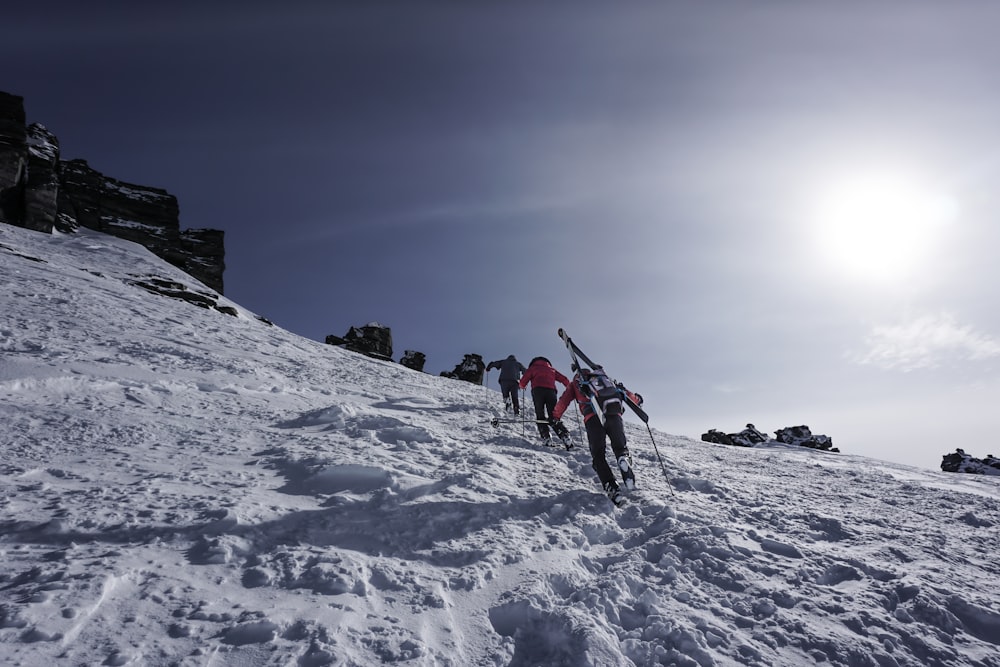 a group of people riding skis down a snow covered slope