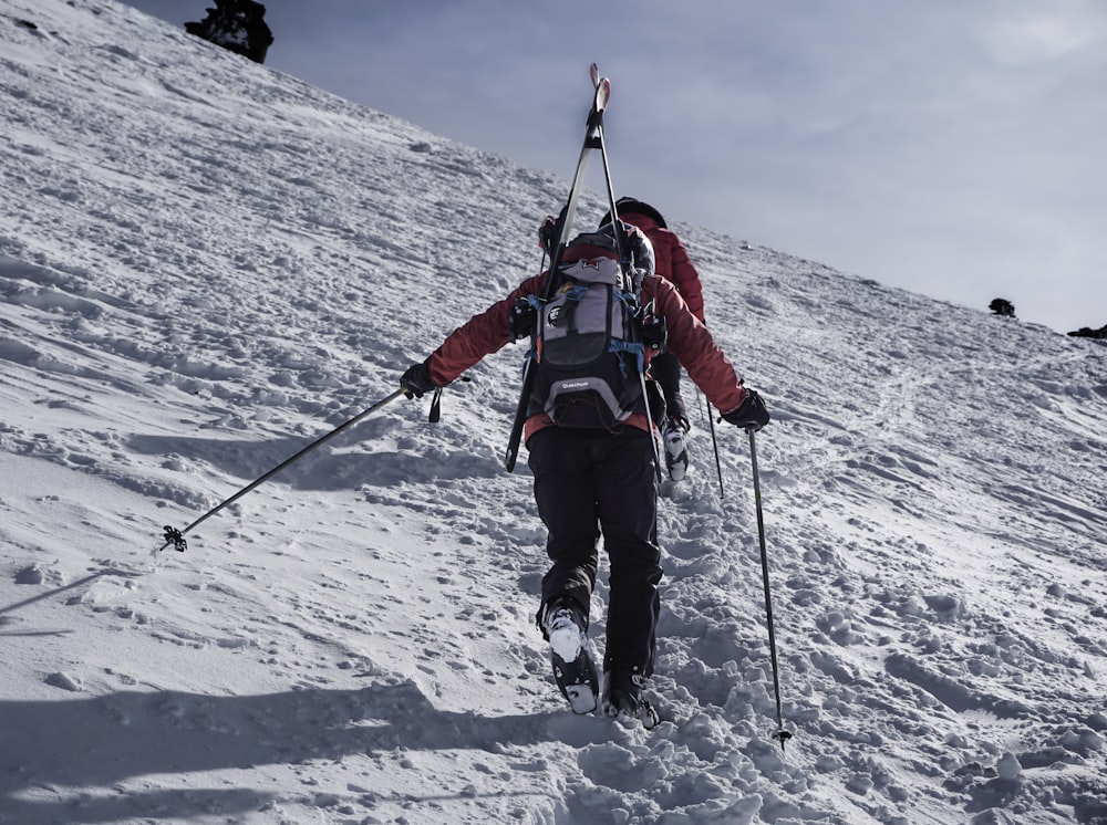 a person walking up a snowy hill on skis