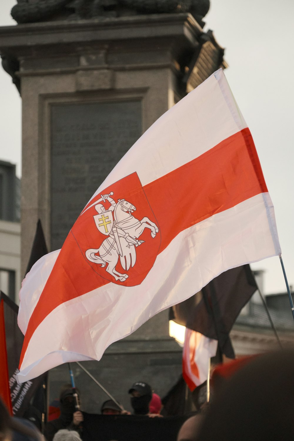 a group of people holding flags in front of a clock tower