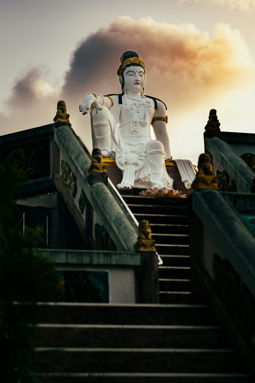 a large white statue sitting on top of a set of stairs