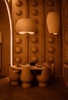 Elegant pendant lights hanging over a wooden table surrounded by ergonomic chairs.