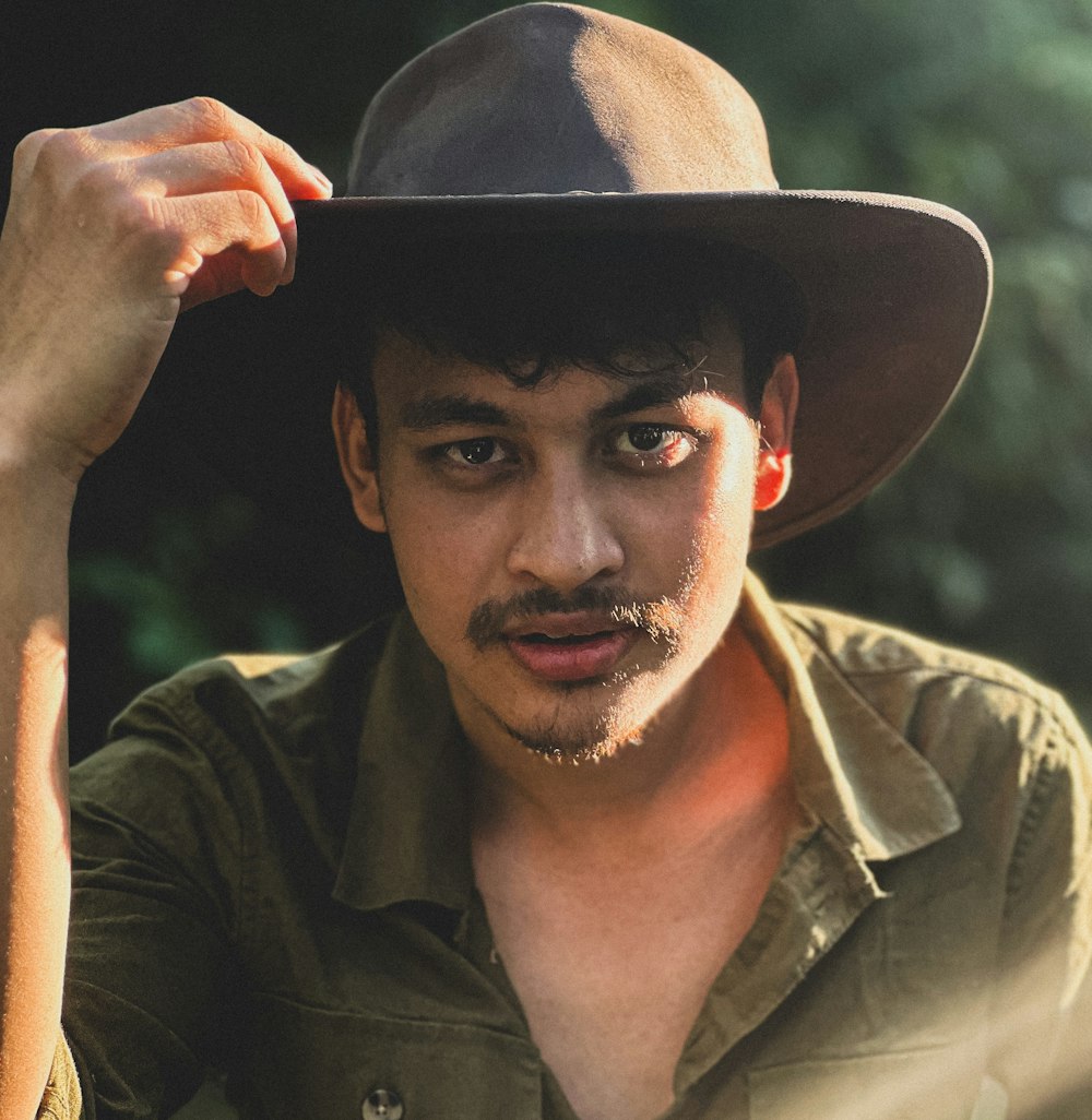 a man in a hat is posing for a picture