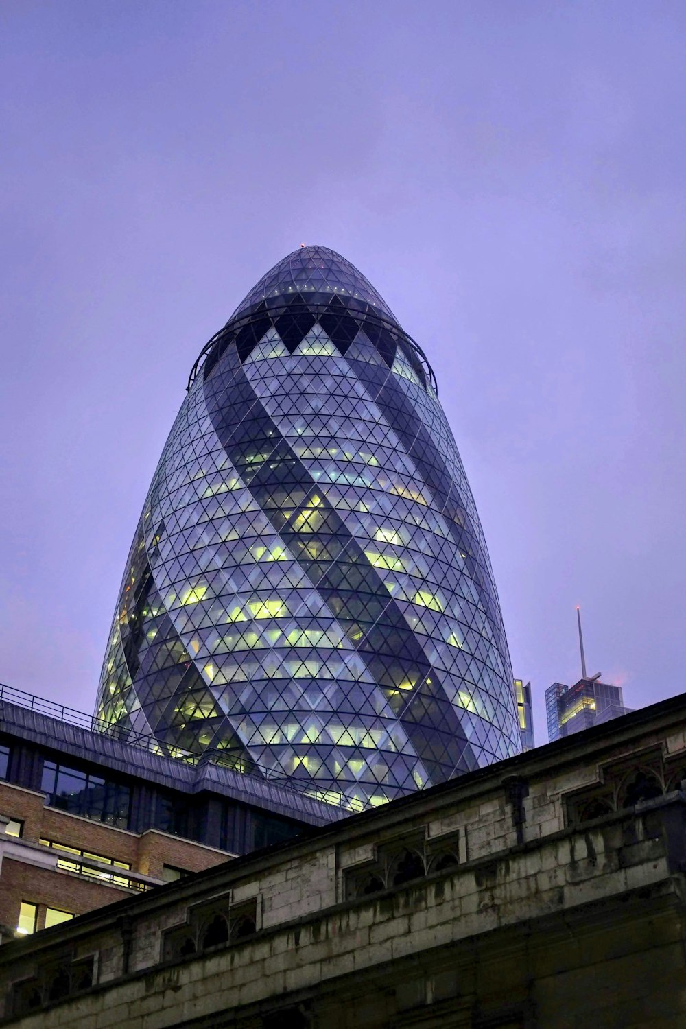 a very tall glass building with a sky background