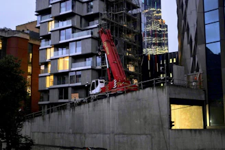 A sleek, modern construction site at sunset with cranes and half-finished buildings showcasing expertise.