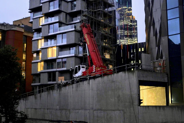 A sleek, modern construction site at sunset with cranes and half-finished buildings showcasing expertise.