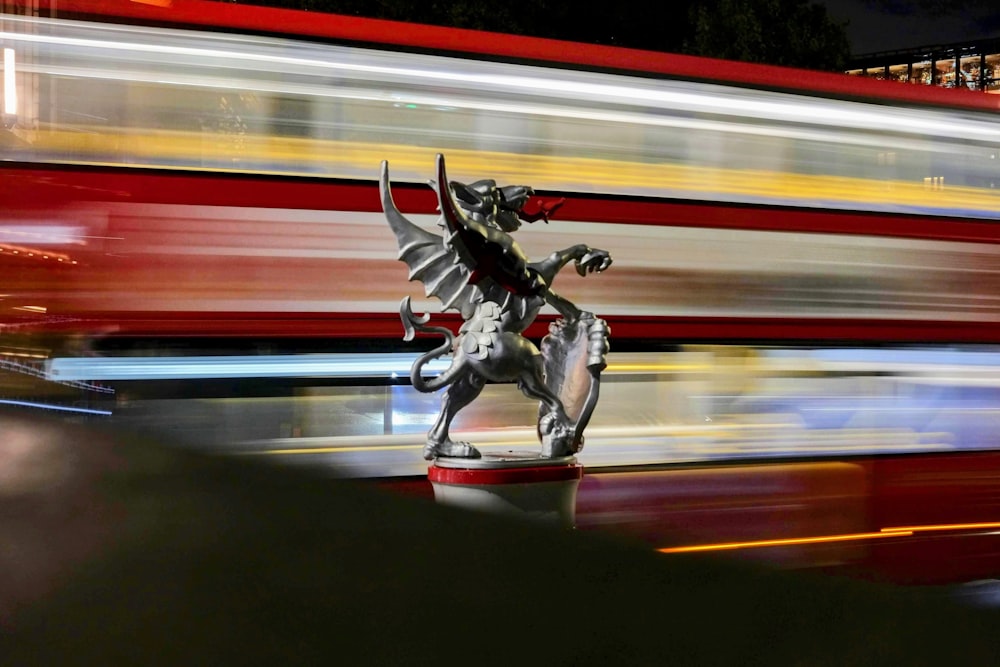 Eine Statue eines Drachen steht vor einem Bus