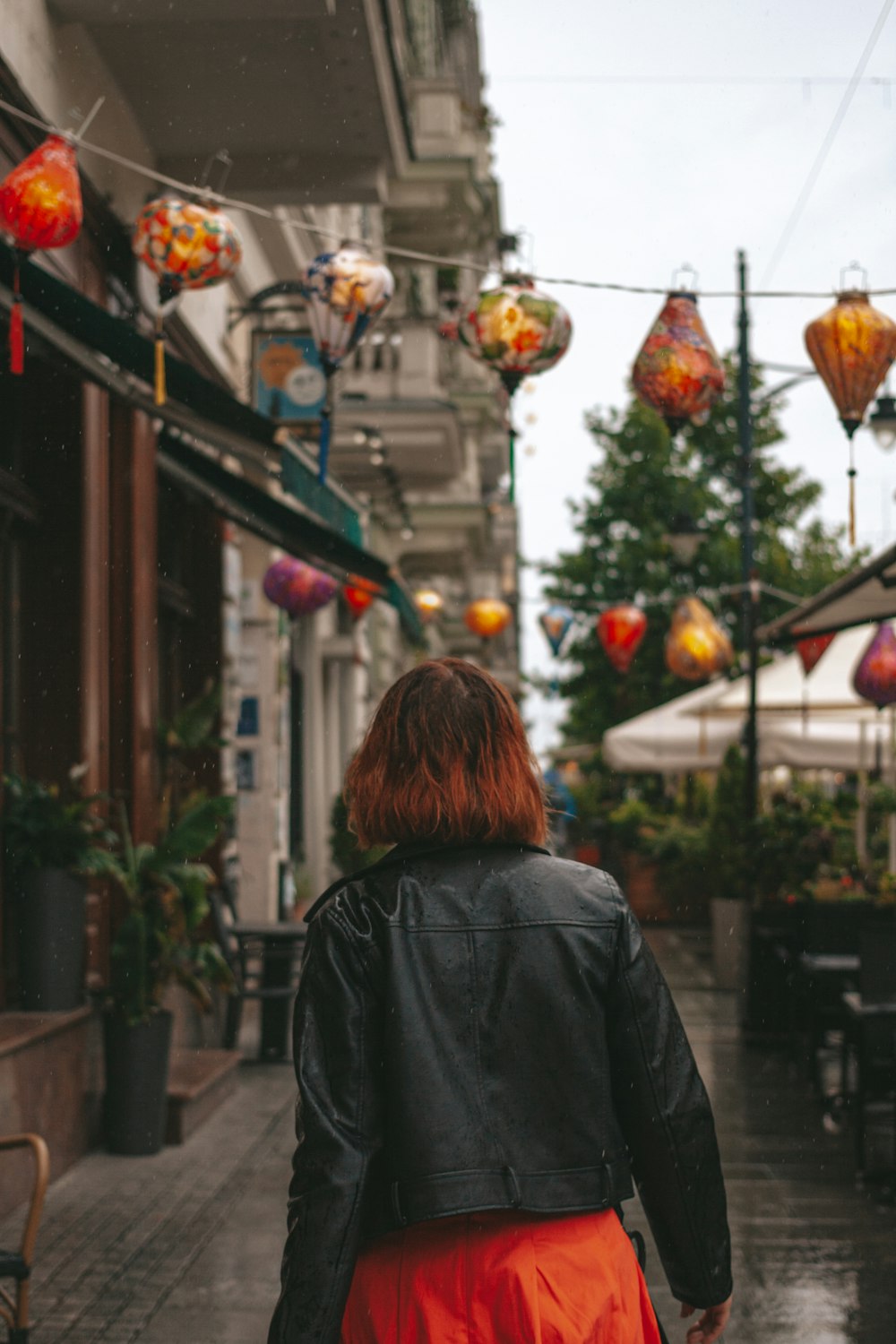 a woman walking down a street in the rain