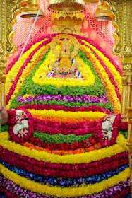 A vibrant flower garland being prepared by devotees in the temple courtyard.