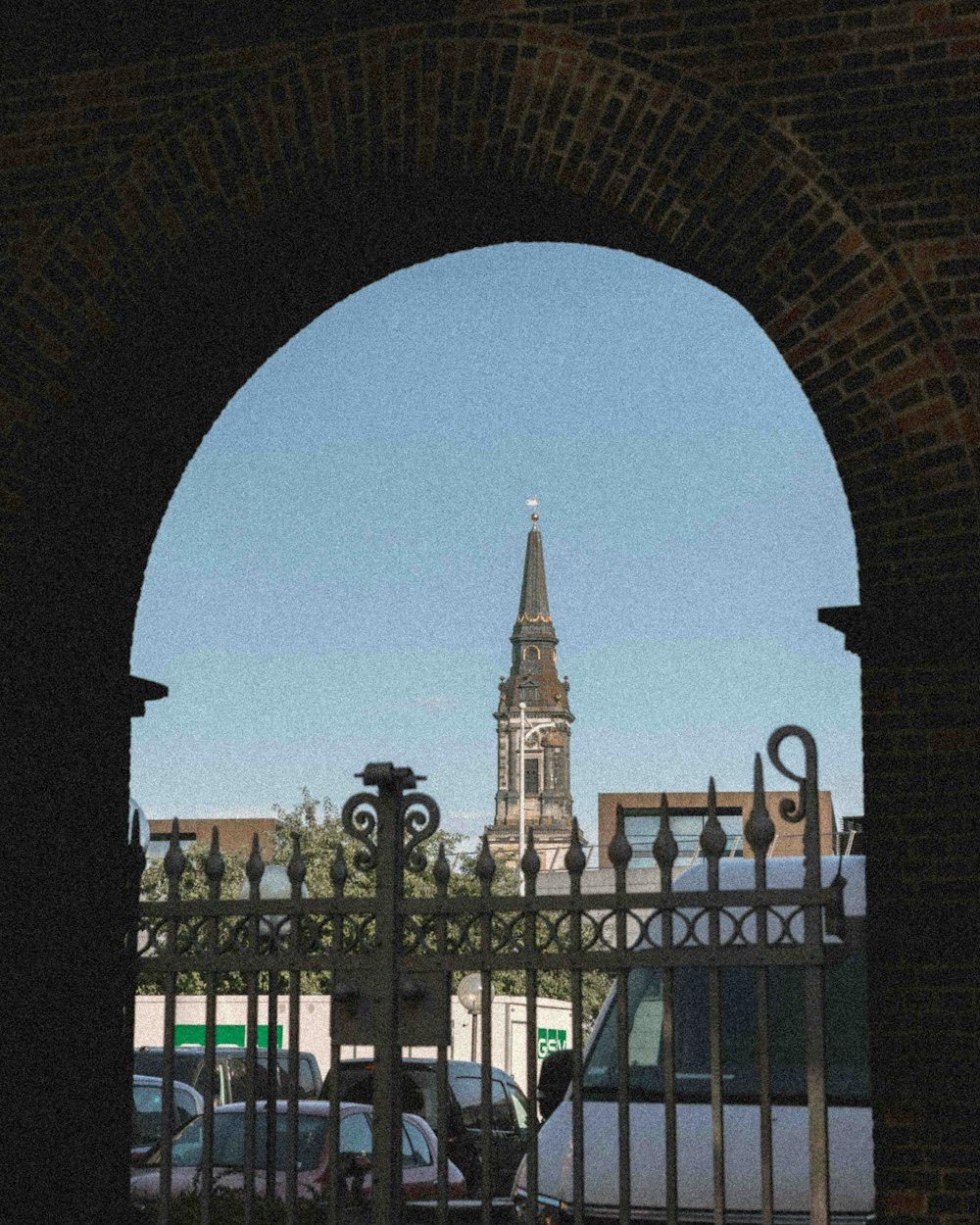 a view of a clock tower through a gate