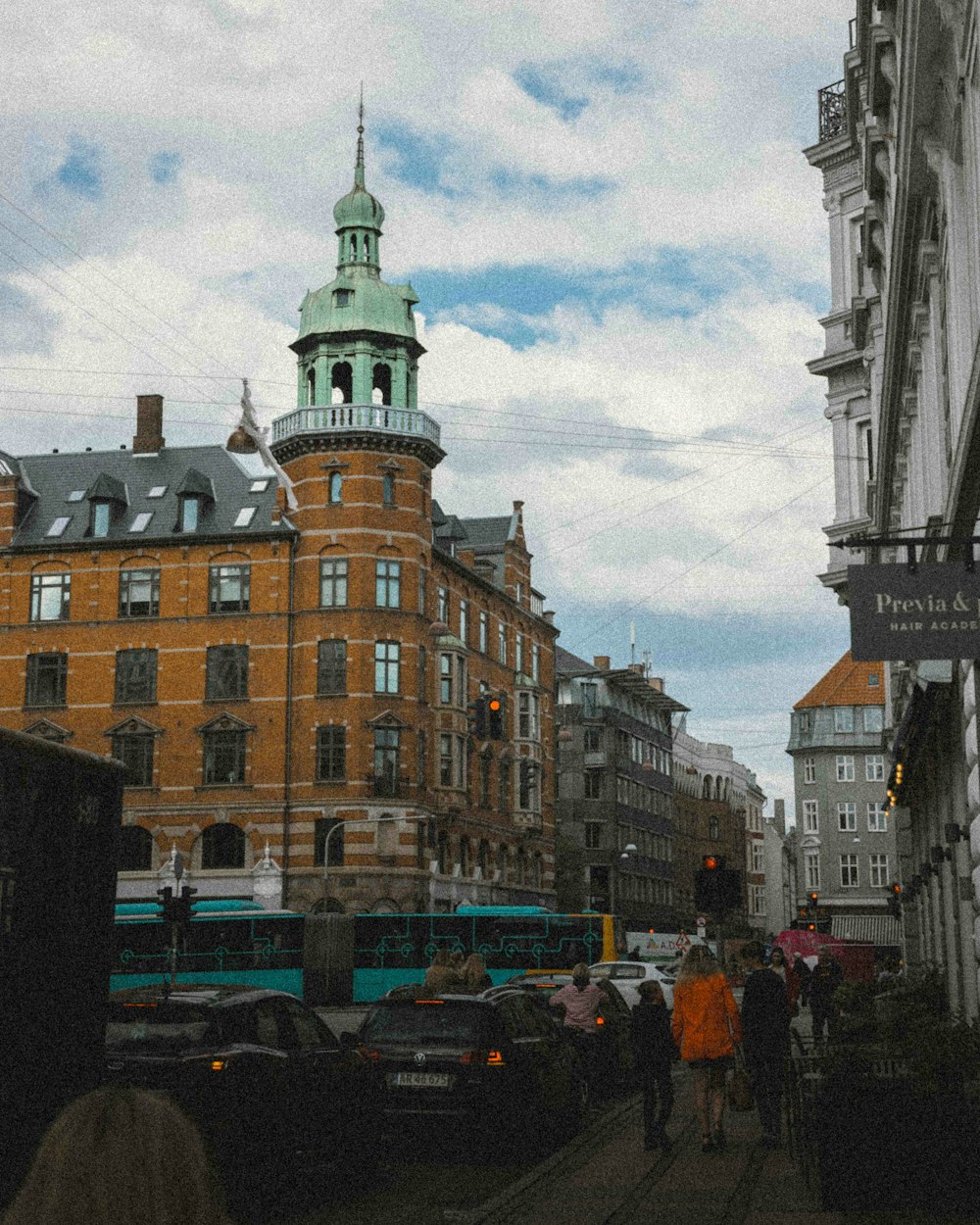 a group of people walking down a street next to tall buildings